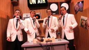 Four men in a sound booth singing